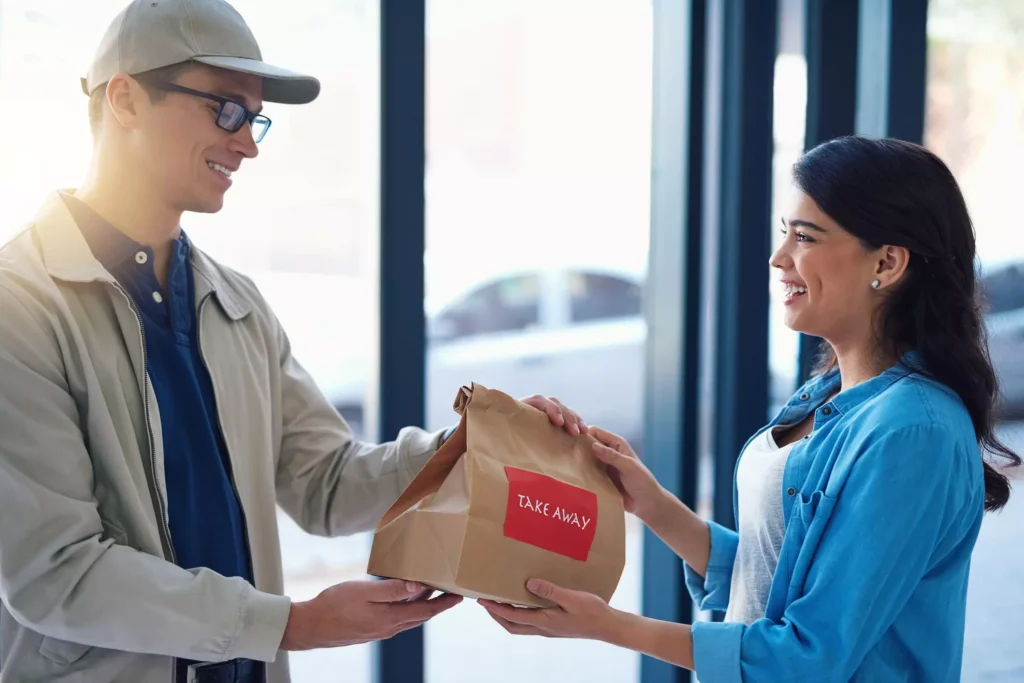 Happy customer receiving takeout food at home